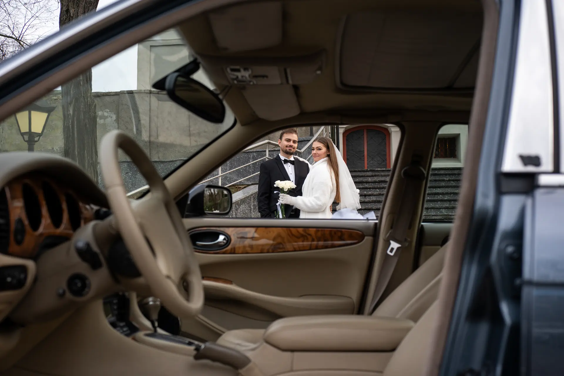 Para młoda przy eleganckim Jaguarze ślubnym