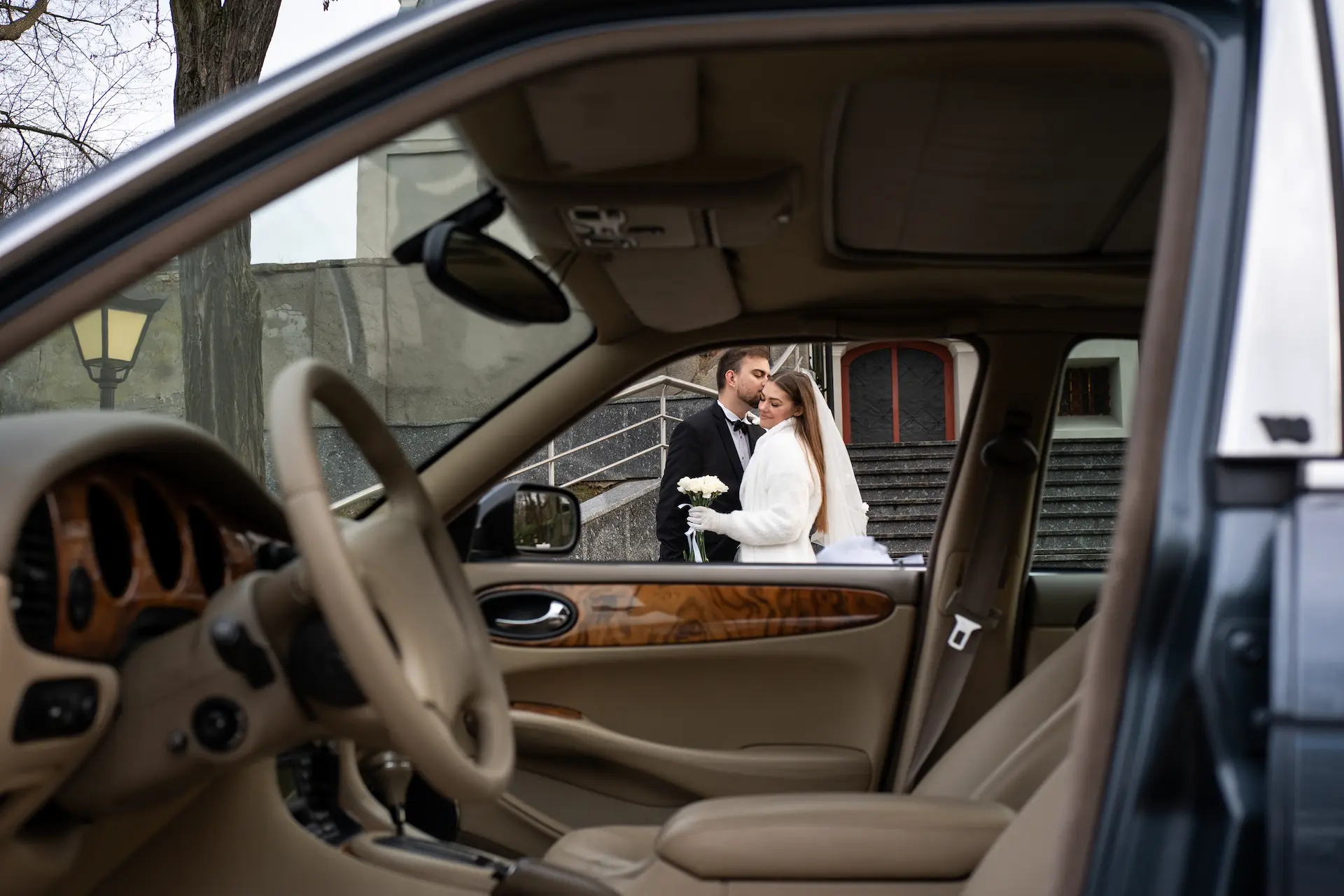 Para młoda przy eleganckim Jaguarze ślubnym