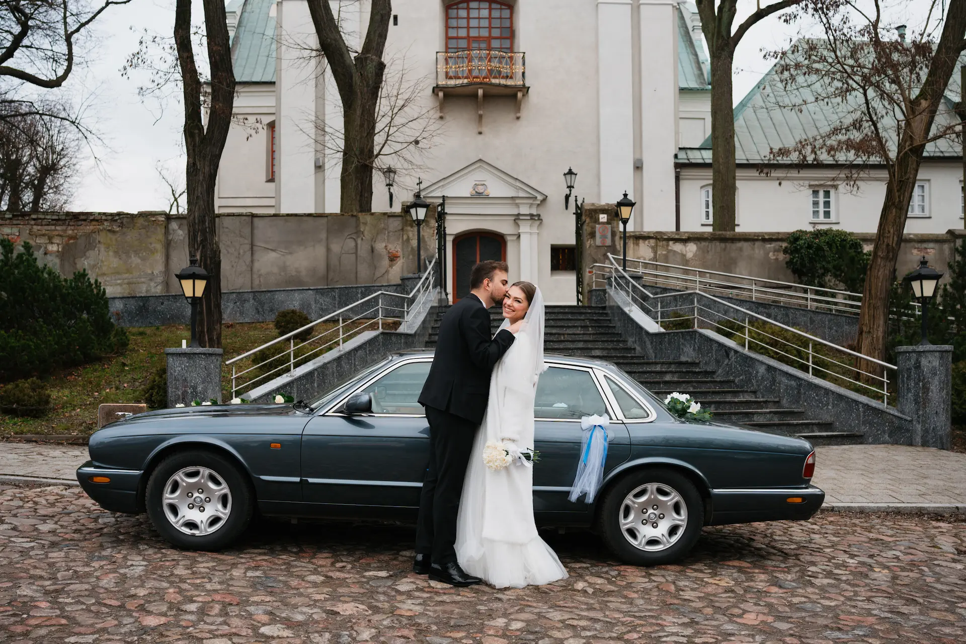 Para młoda przy eleganckim Jaguarze ślubnym